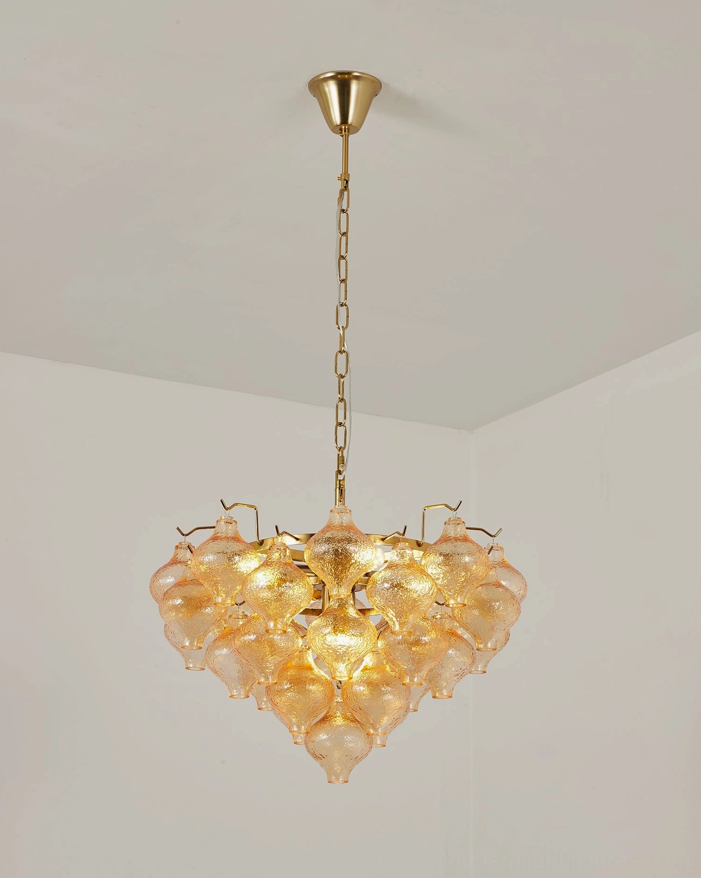 Vetrina amber tulip glass chandelier low-angle corner room view in minimalist empty interior space with brass metal suspension hardware