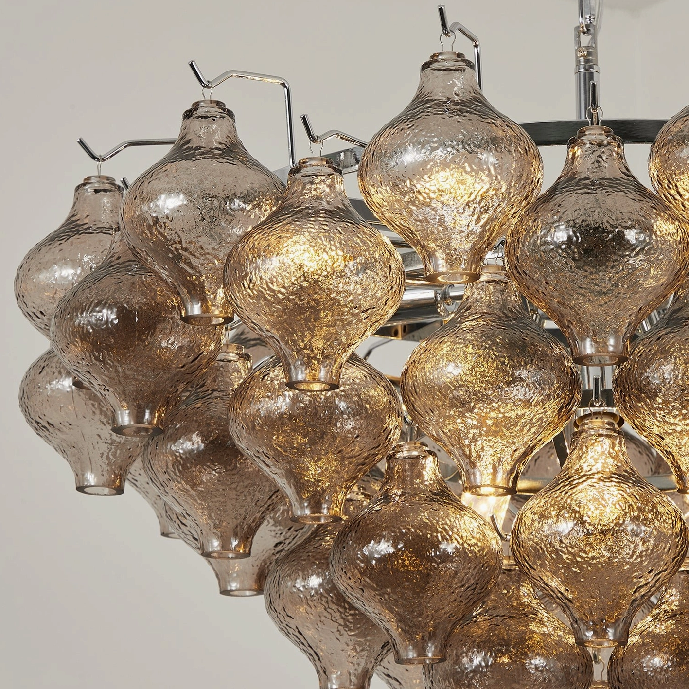 Vetrina large tiered tulip glass chandelier in open stairwell with natural light creating sculptural shadow patterns on ceiling