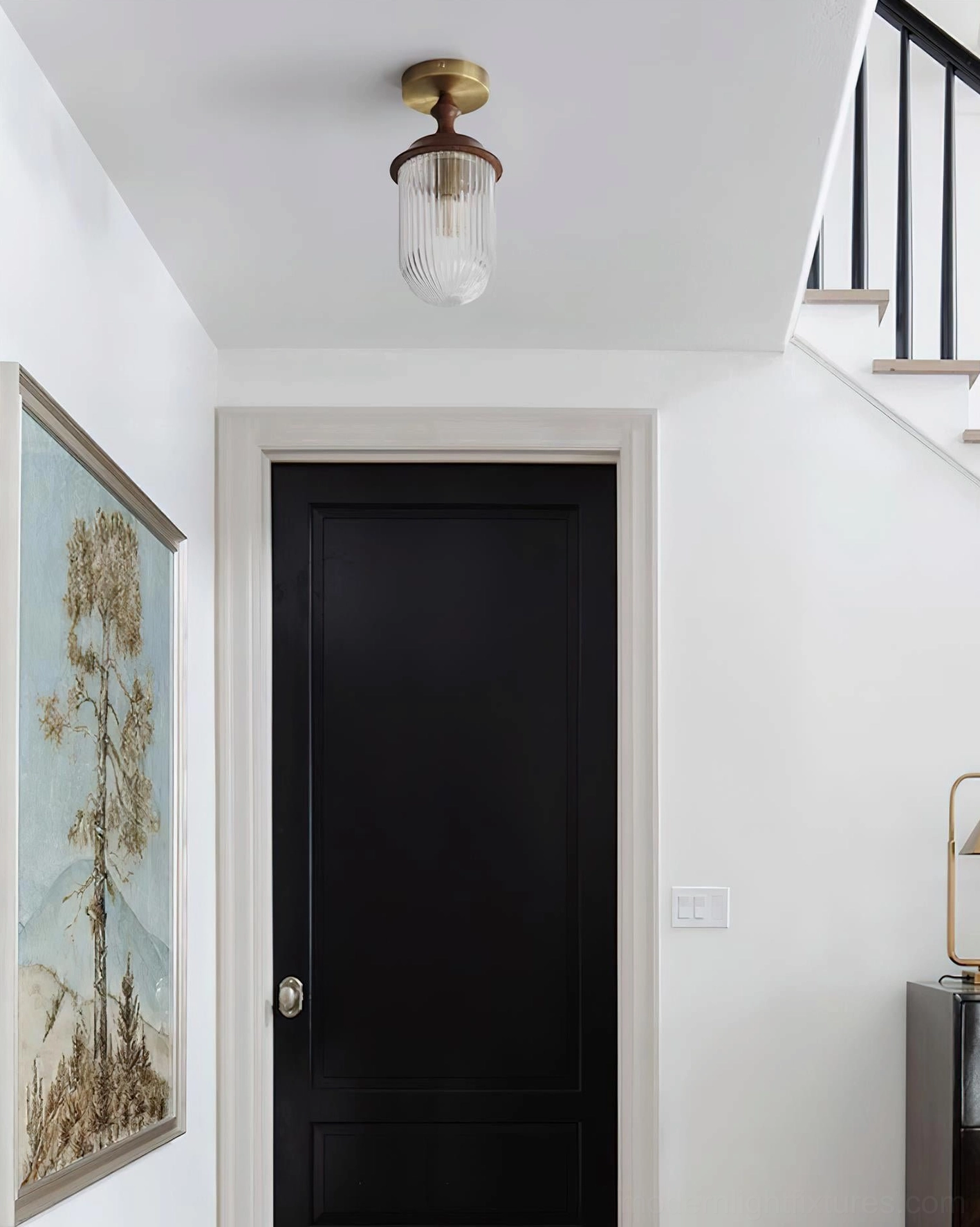 Veyra brass and wood ceiling light fixture installed in minimalist vintage residential hallway with staircase