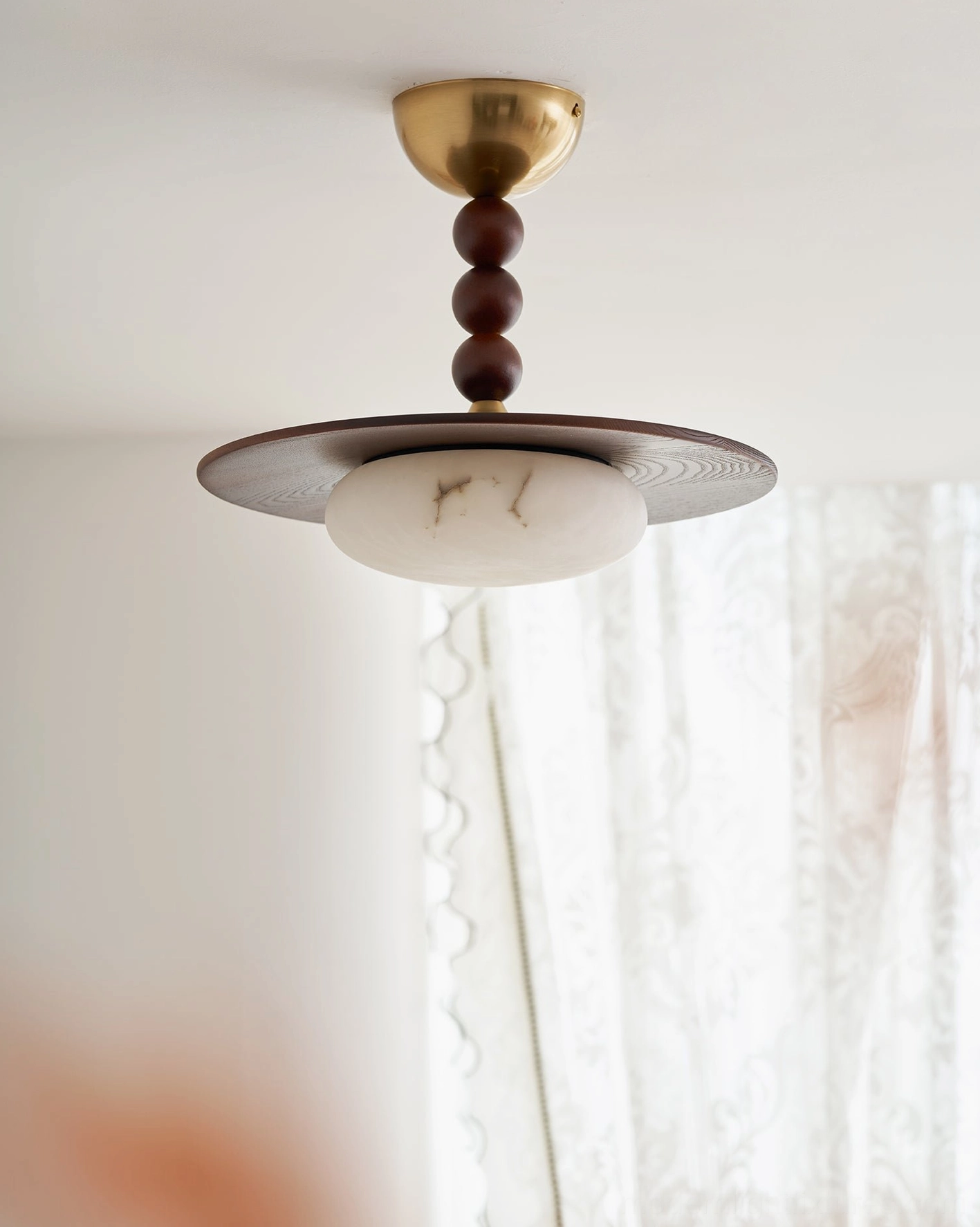 Vicenza modern ceiling light fixture with beaded brass stem over covered porch area