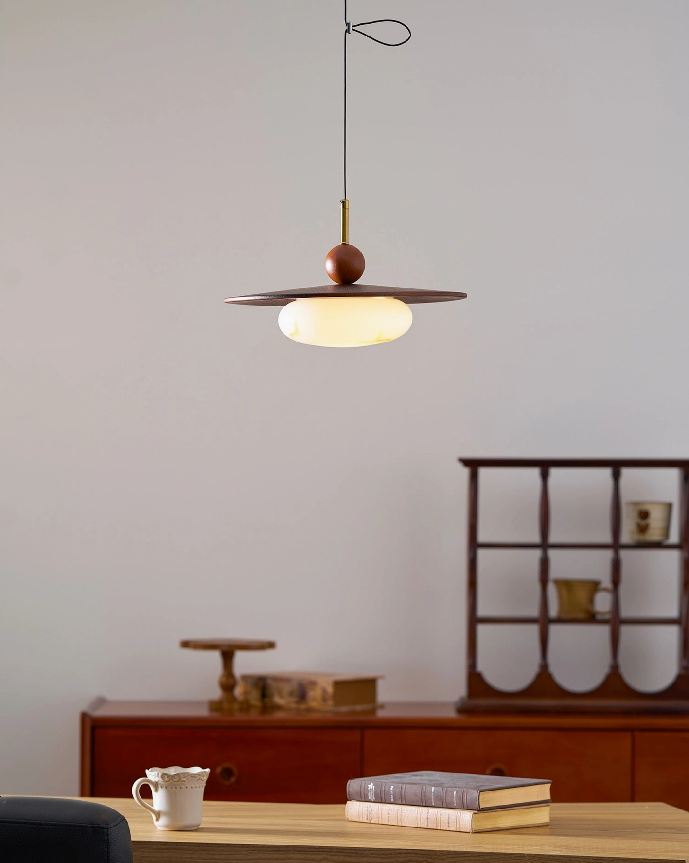 Modern swing arm pendant light in residential kitchen showing warm ambient lighting and wood material