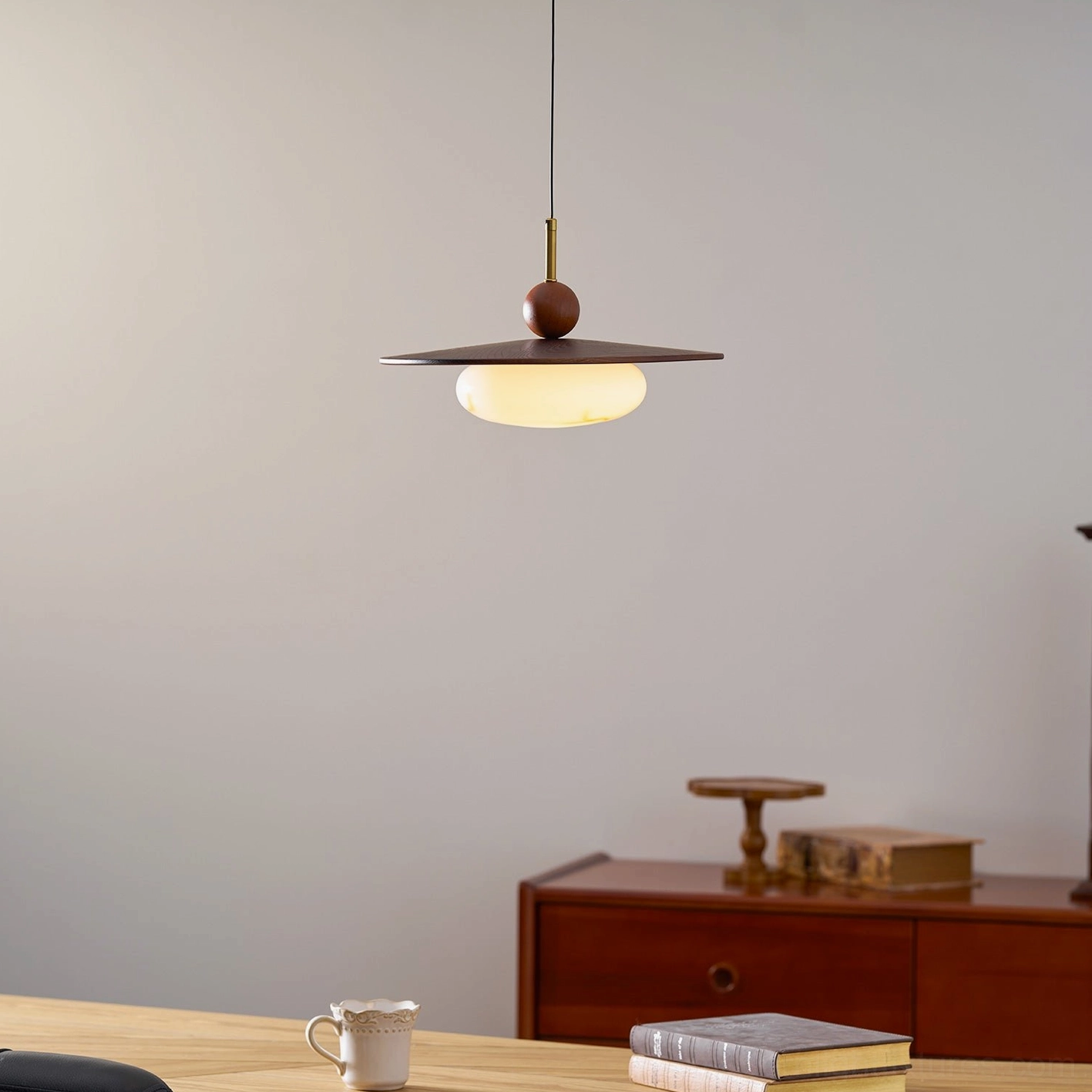 Swing arm pendant light installed residential dining space with contemporary design and warm lighting
