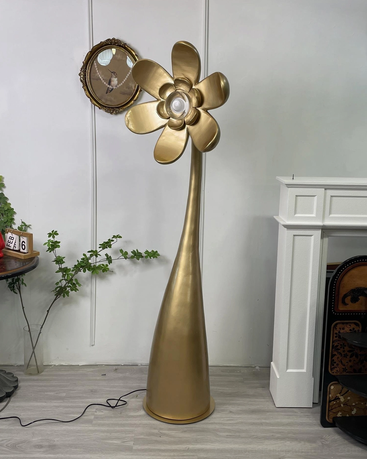 Brushed gold Vicenzio flower lamp in vintage living room with fireplace - modern sculptural lighting fixture