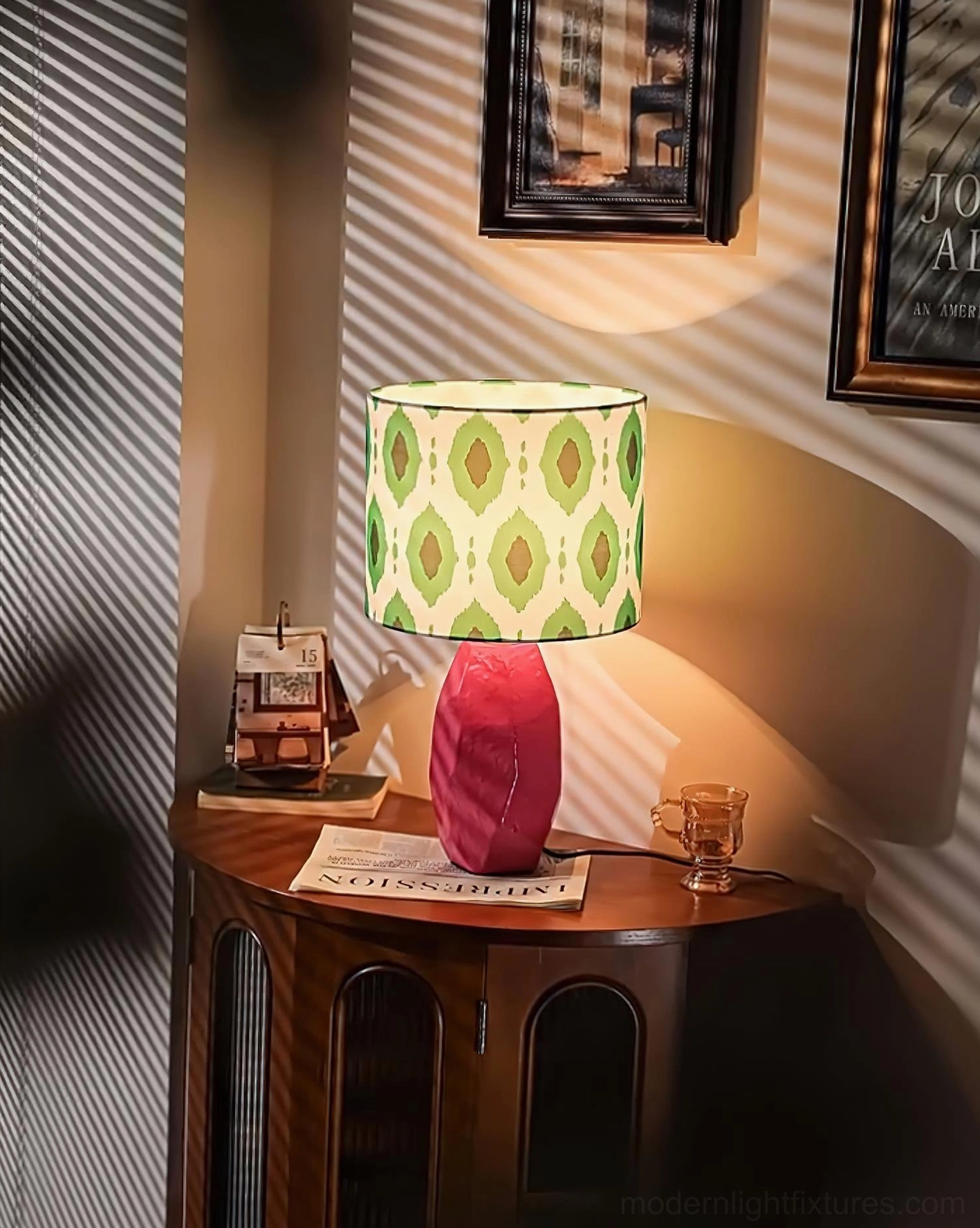 Vico artistic geometric table lamp glowing with warm ambient light, low angle view with pink ceramic base casting shadow on vintage wall