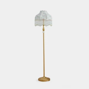 Victorian floor lamp with gold metal pole and floral fabric shade on white background