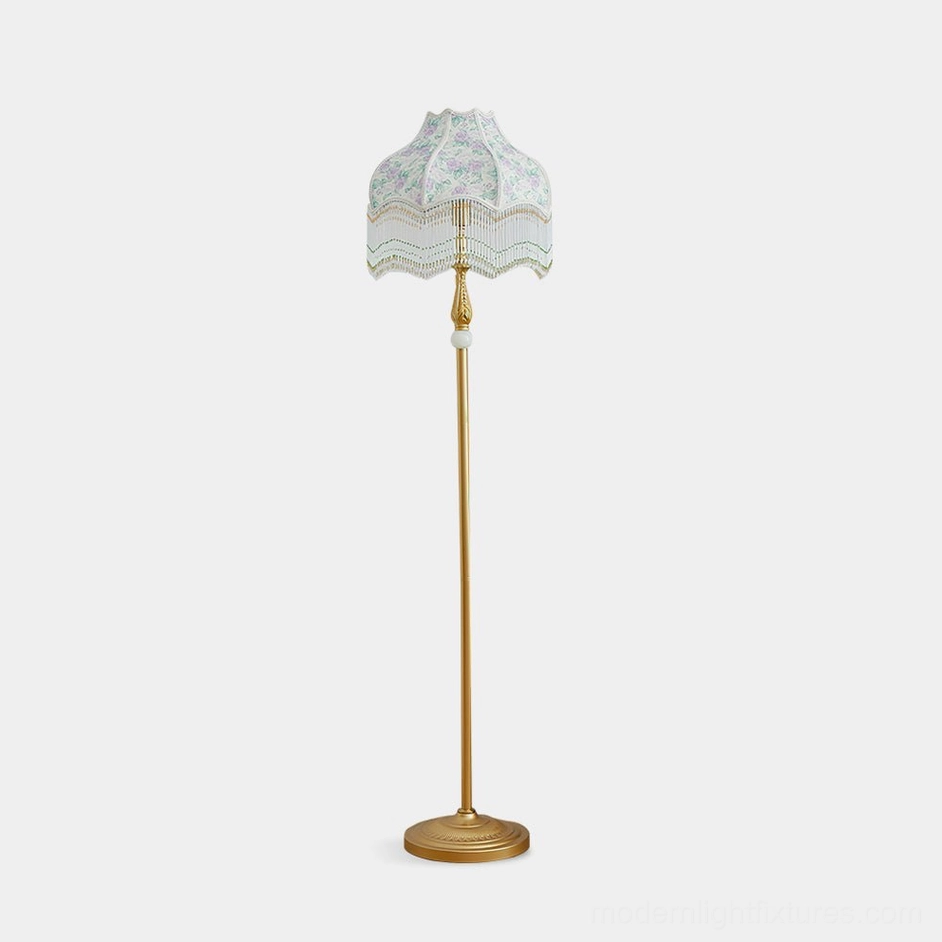 Victorian floor lamp with gold metal pole and floral fabric shade on white background