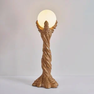 Lit Victory artistic table lamp with frosted glass orb and twisted brown resin base three-quarter view