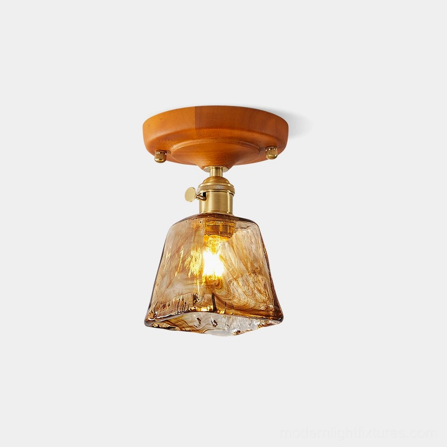 Vintage amber glass ceiling light fixture with brass hardware and solid wood canopy, front studio view showing trapezoid hand-blown glass shade