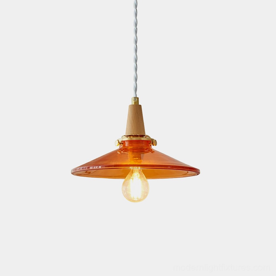 Vintage amber glass pendant light with brass hardware and natural wood accents, front view on white background