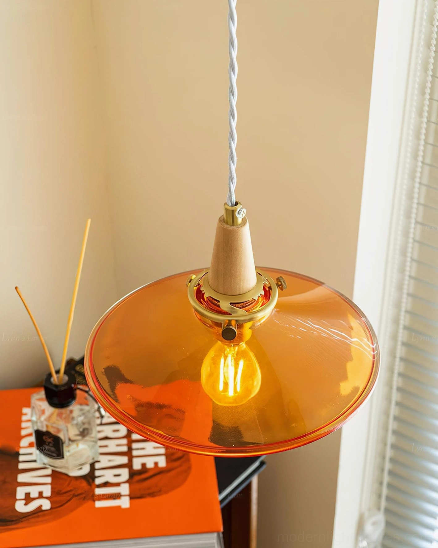 Vintage amber glass pendant light architectural detail showing suspension system and shade construction