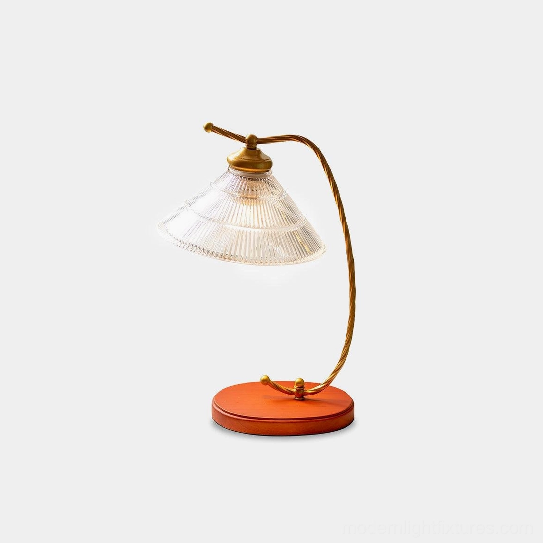 Vintage arc reading table lamp with curved brass-gold metal arm, terracotta wooden base, and fluted clear glass shade, front three-quarter view