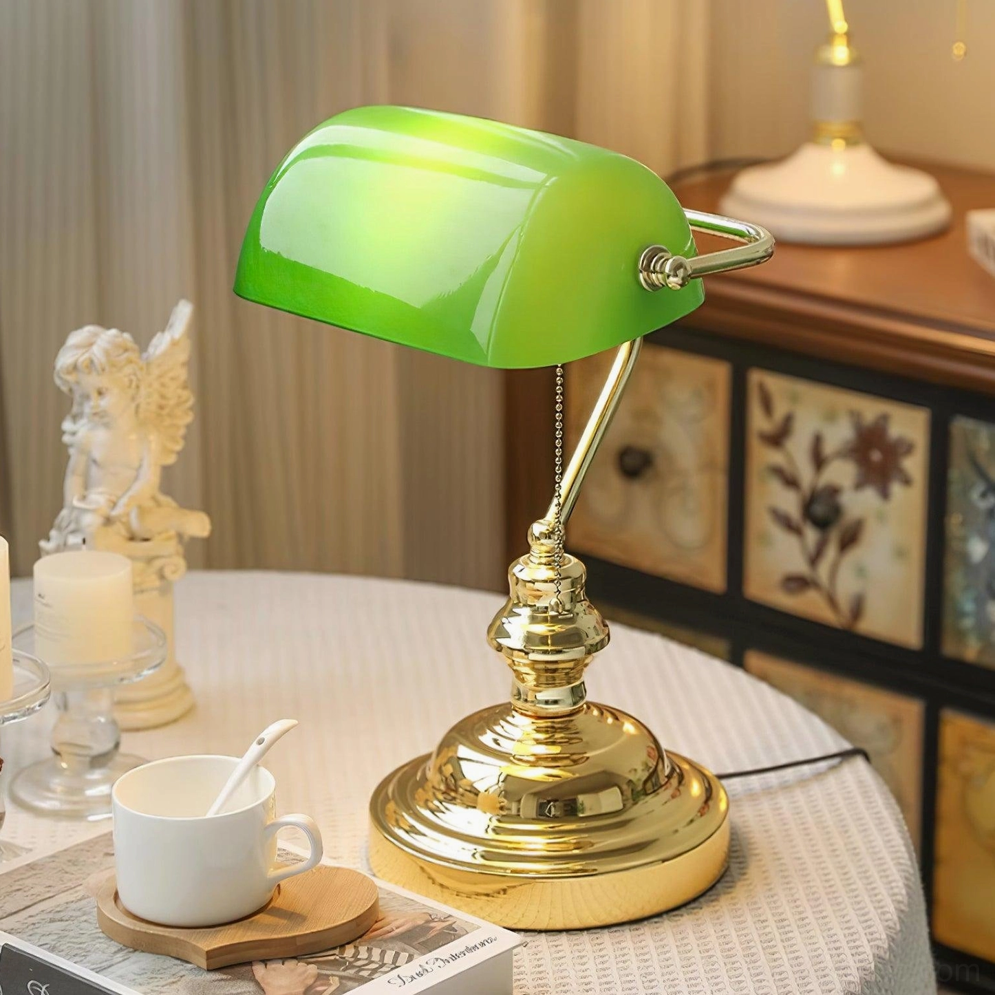 Banker table lamp styled on home tabletop with green glass shade and decorative ornaments