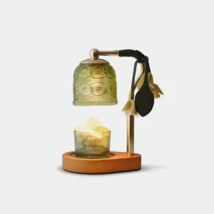 Vintage botanical candle warmer lamp with embossed green glass shade and gold-toned metal base featuring sculptural leaf-and-bloom detailing