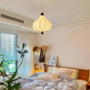 Vintage fabric pendant light in bedroom setting, warm glow illuminating botanical illustrations on white shade