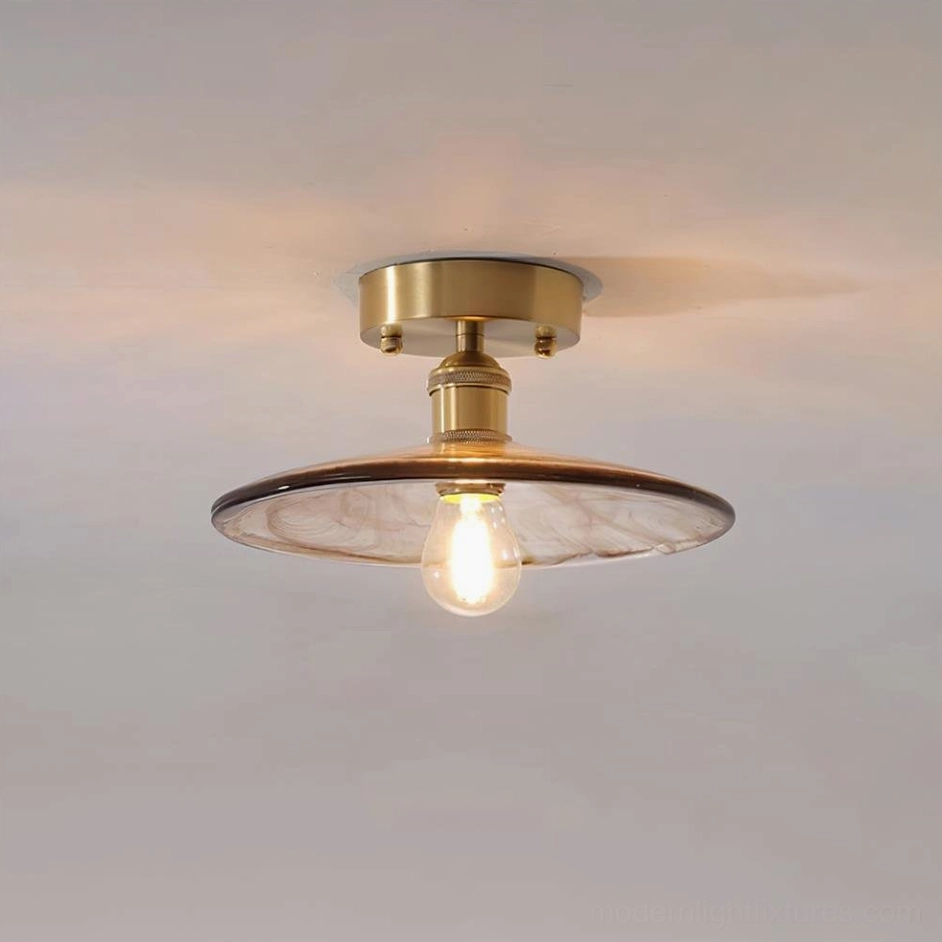 Vintage brass and amber glass semi-flush ceiling light with artistic design, mid-century modern aesthetic