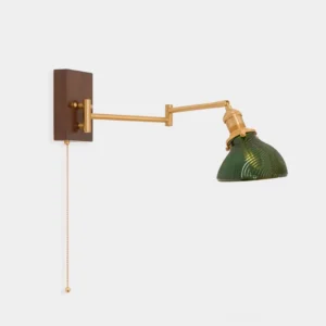 Vintage brass swing arm wall sconce with green ribbed dome shade, front view on white background