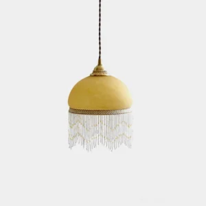 Vintage brass tassel pendant light with frosted yellow glass dome and beaded fringe trim, front studio view