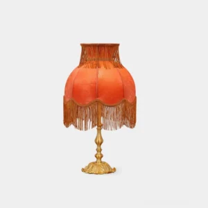 Vintage brass tassel table lamp with burnt orange velvet fringe shade and ornate base, front studio view