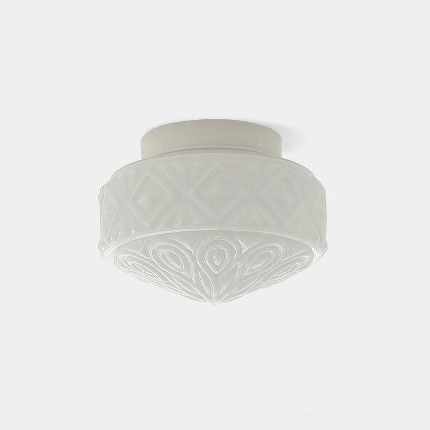 Embossed vintage glass ceiling light fixture with carved diamond and scroll pattern in white finish, front view against studio backdrop