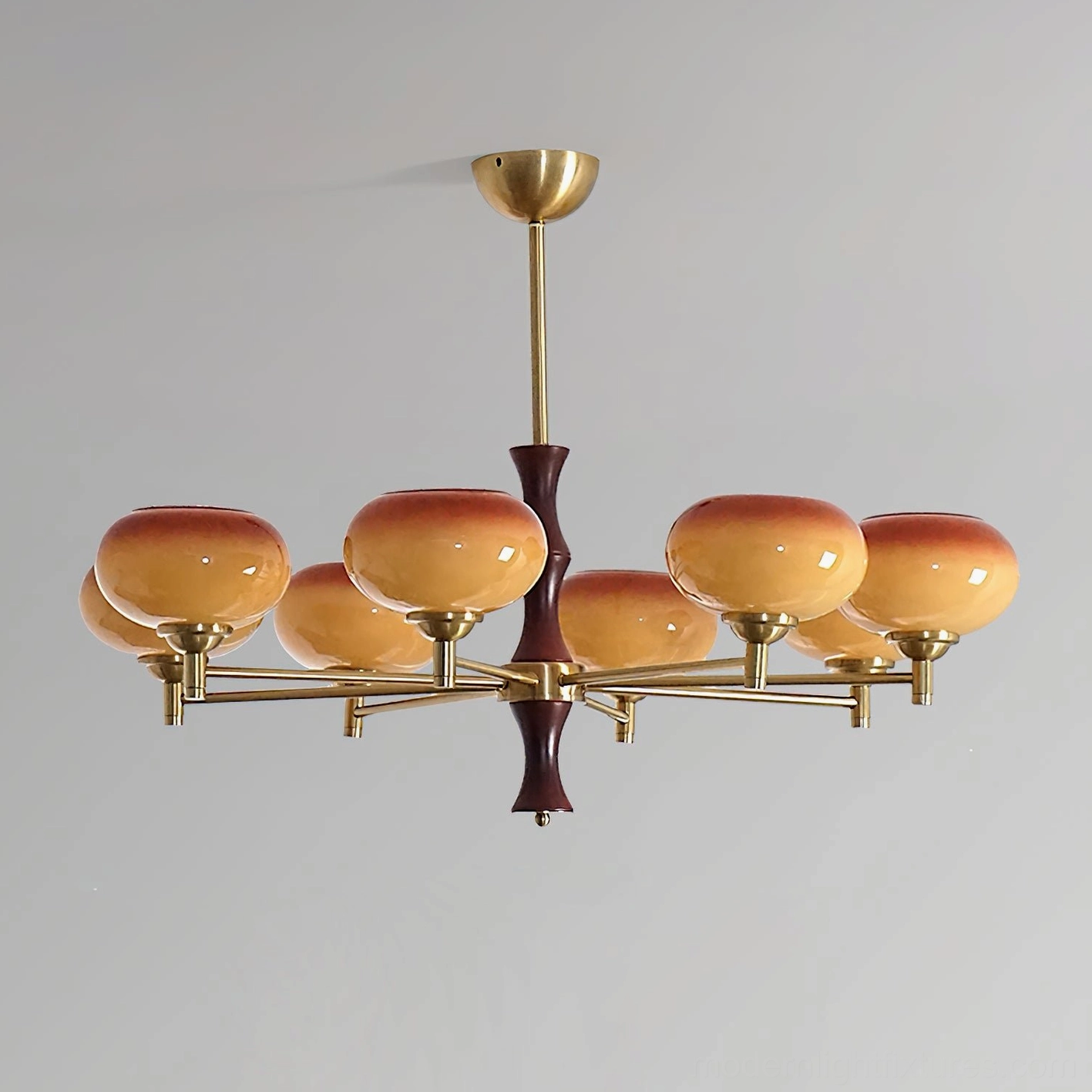 Vintage mid-century modern chandelier close-up showing brass arm construction, gradient glass shade details, and warm lighting effect