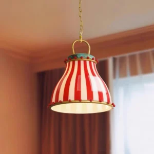 Retro circus striped pendant lamp glowing warm light with brass hanging chain in cozy room setting