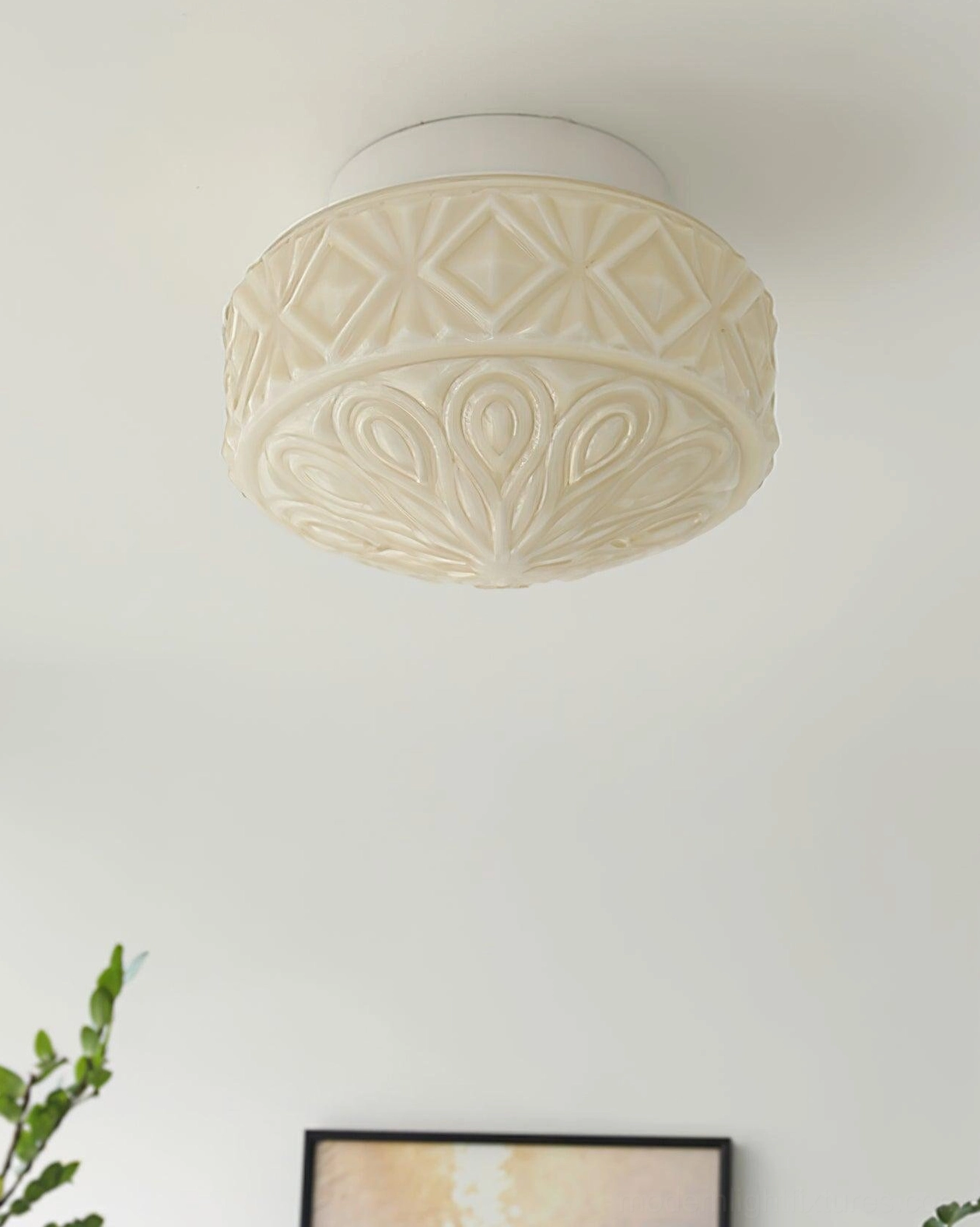 Cream beige embossed glass ceiling light with intricate scroll pattern in minimalist home interior corner