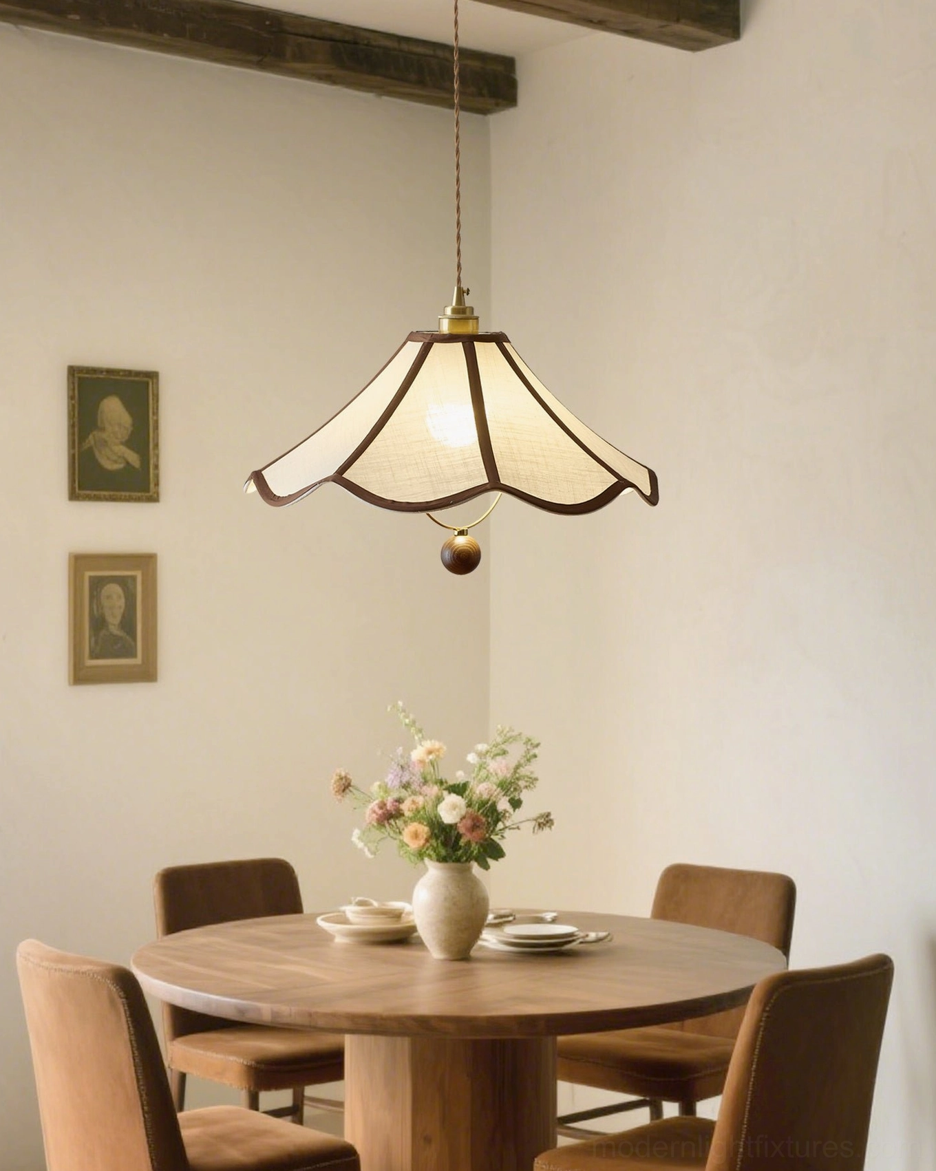 Vintage pendant light creating warm ambiance above round wooden dining table with artwork