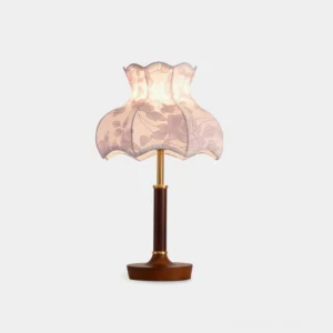 Vintage floral table lamp with scalloped fabric shade and wooden base, front view on white studio background