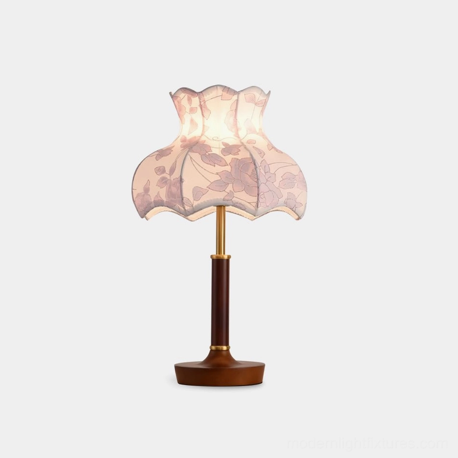 Vintage floral table lamp with scalloped fabric shade and wooden base, front view on white studio background