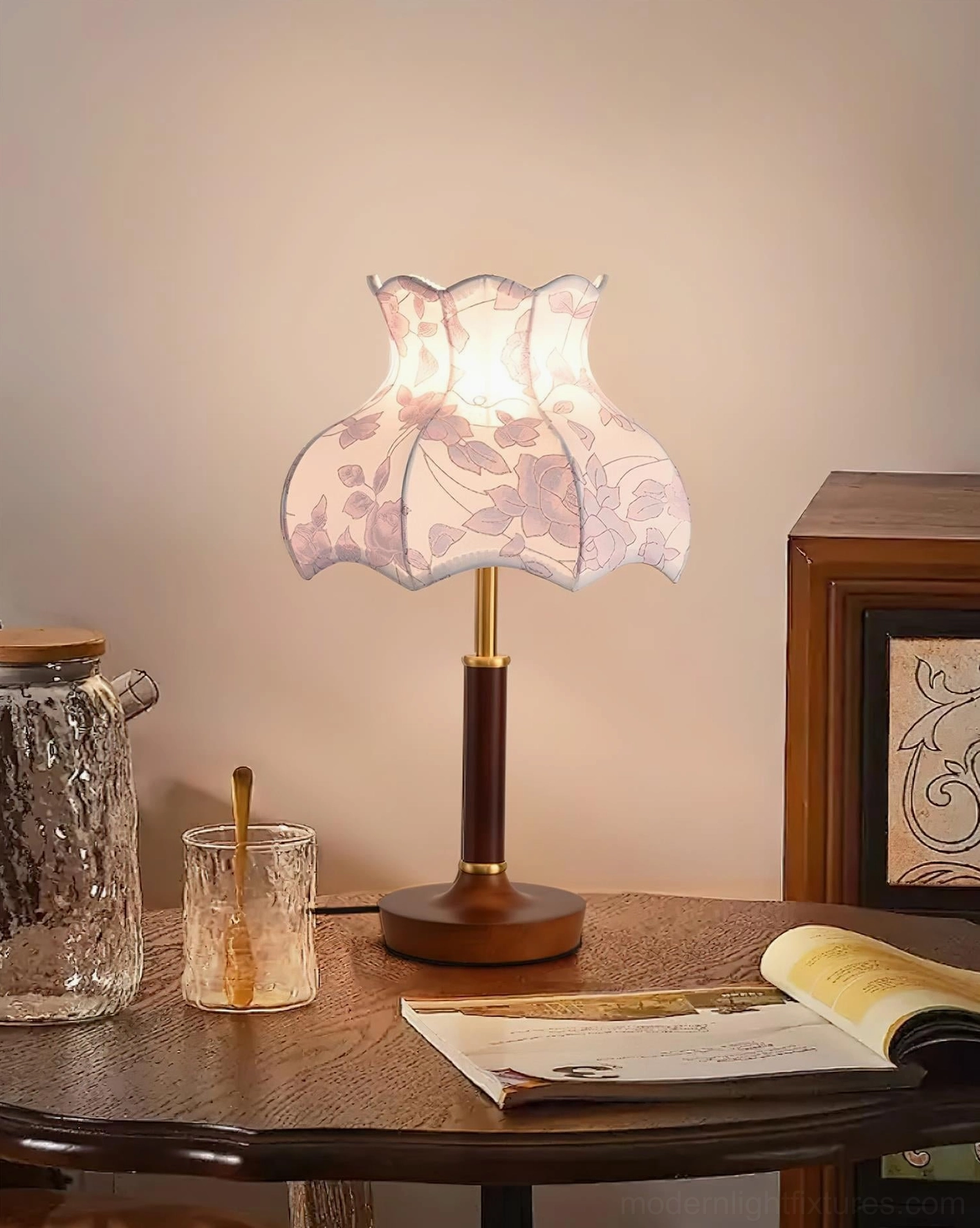 Vintage floral table lamp on round wooden dining table with books and glassware, warm living room ambiance