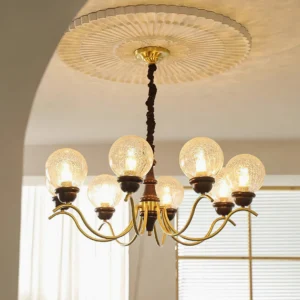 Retro brass globe chandelier with crackled glass shades installed in French-style dining room with louvered windows and ceiling medallion
