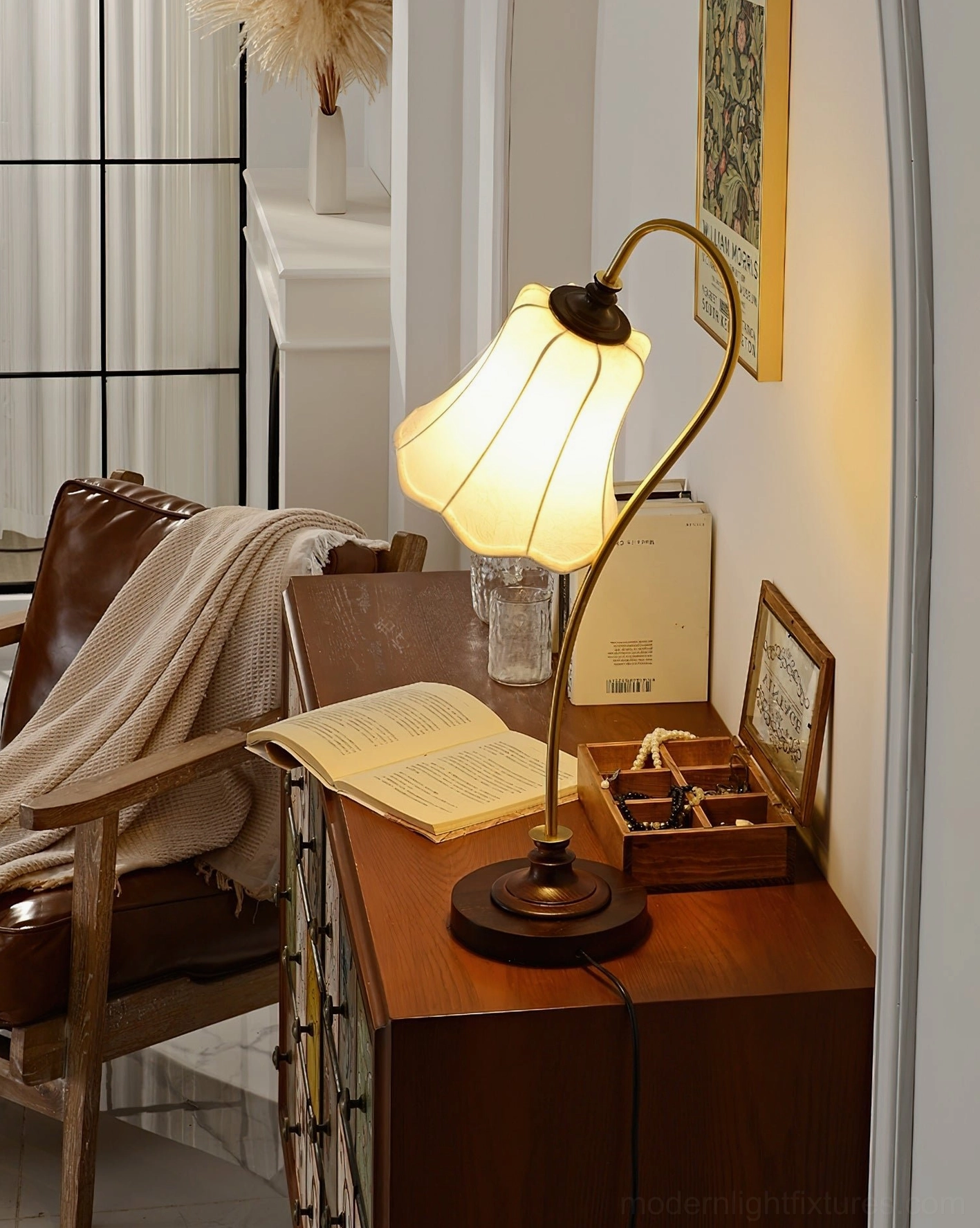 Vintage gooseneck table lamp with lit lace fabric shade on wooden side table in home study