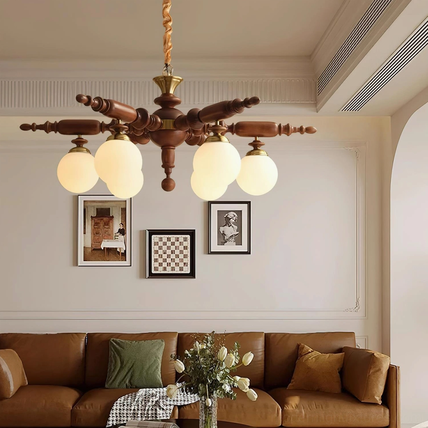 Wooden vintage chandelier with dual arms in French-style living room with leather sofa