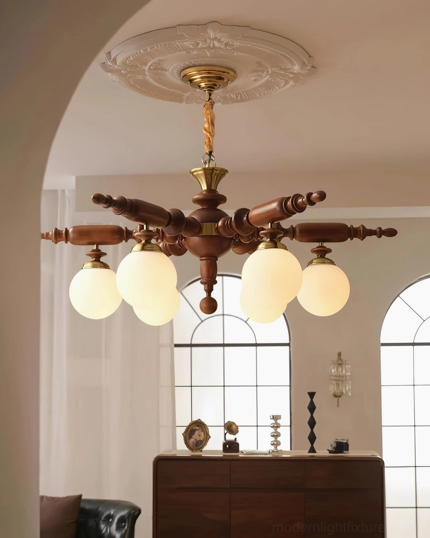Brown wooden vintage chandelier with brass hardware in retro living room with cabinet