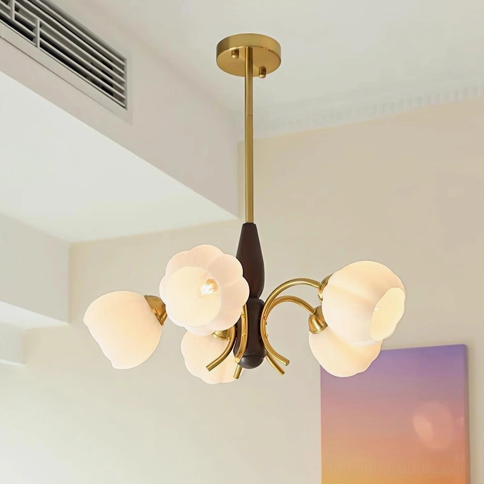 Orillia chandelier installed in living room showing warm brass hardware and frosted milk glass petal shades, low-angle perspective
