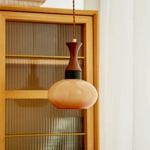 Mid-century modern hanging pendant lamp with warm amber glass in dining room above round table