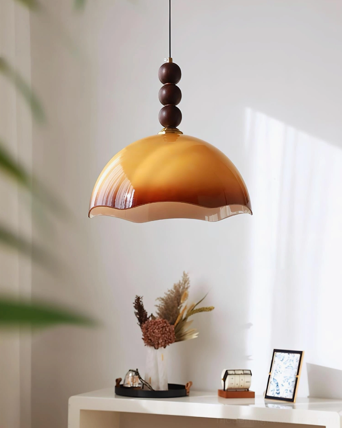 Side view of vintage-style amber rippled pendant light displayed on minimalist console table with warm cottage ambiance