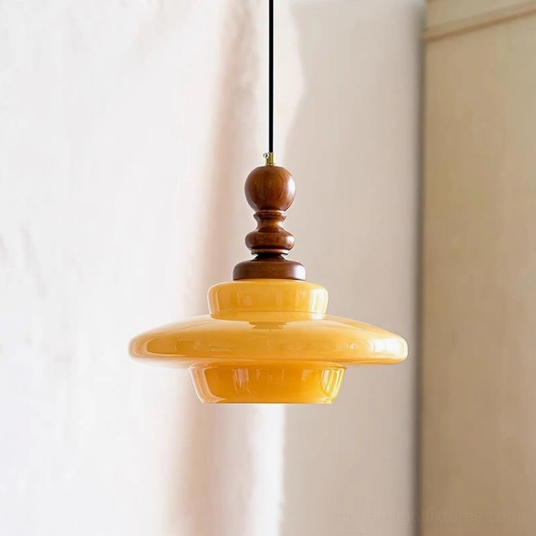 Mid-century modern pendant lamp with golden amber glass shade and walnut wood hardware, indoor three-quarter angle view