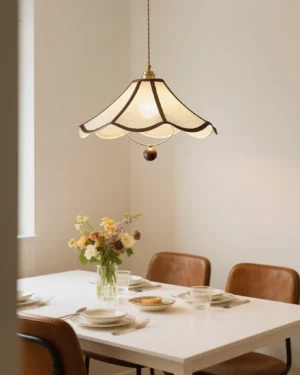 Vintage scalloped pendant light illuminated above formal dining table with floral centerpiece