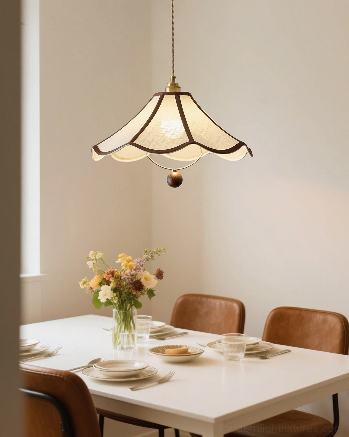 Vintage scalloped pendant light illuminated above formal dining table with floral centerpiece