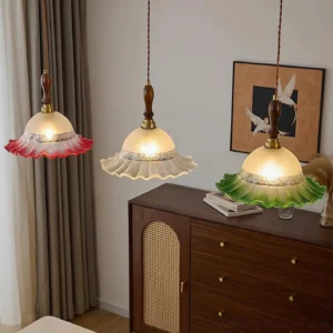 Multiple Brielle pendant lights in clear and red glass shades installed in bedroom with wooden furniture