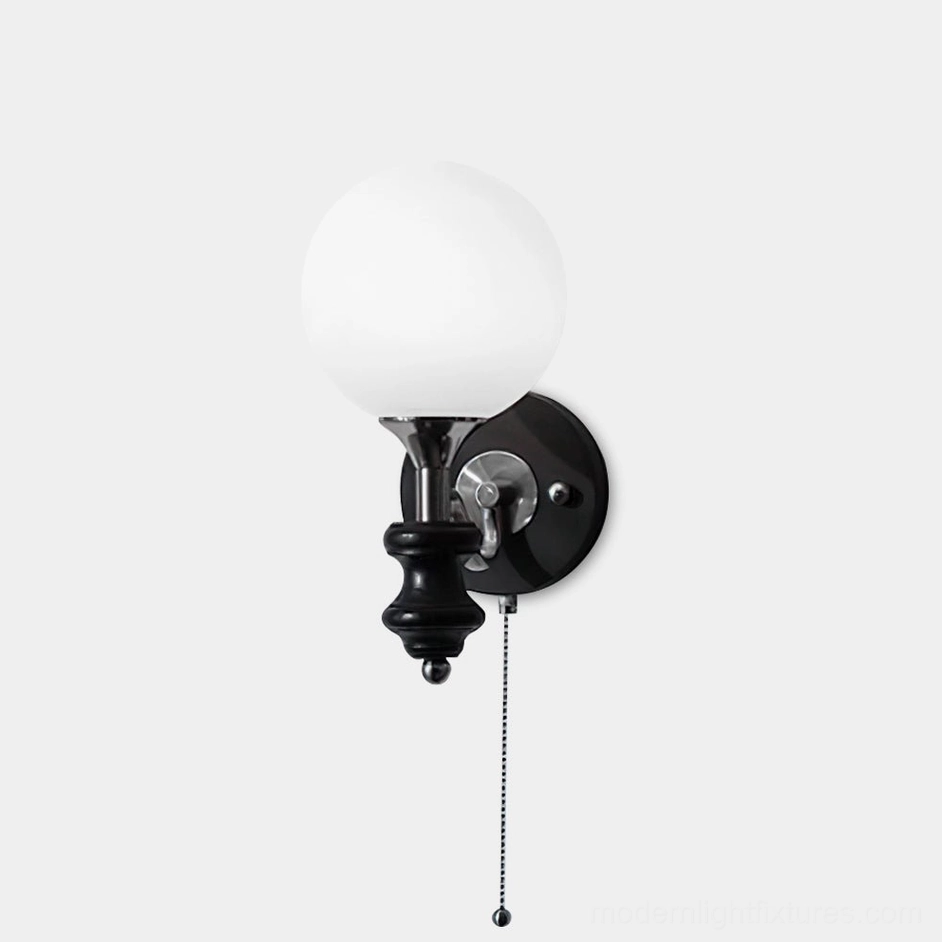 Vintage spherical wall sconce with frosted white glass globe and matte black metal base, front studio view