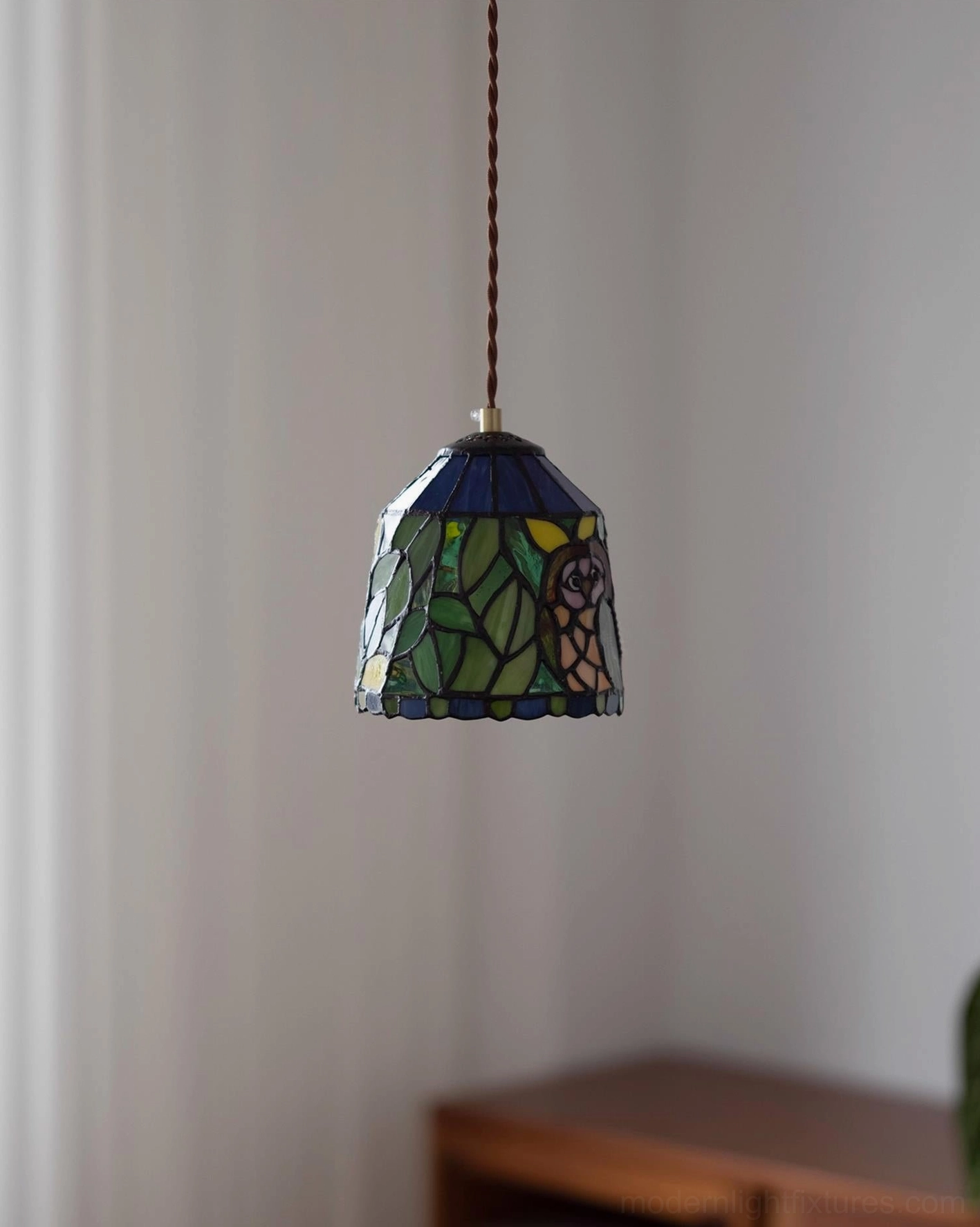 Vintage stained glass pendant lamp with geometric and animal pattern glass panels suspended from brass cord