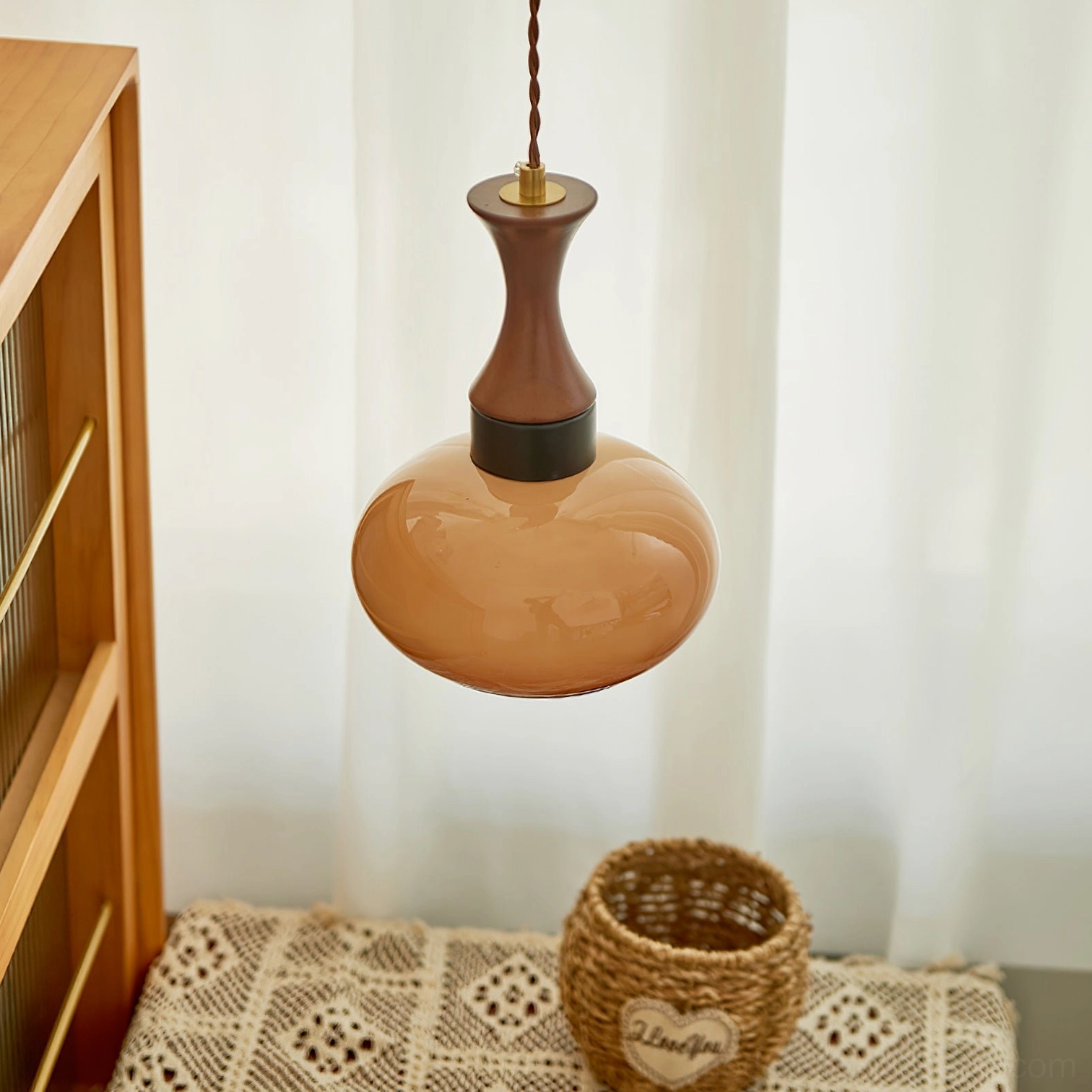 Chara pendant lamp in cozy corner with warm amber brown glass and woven basket decor