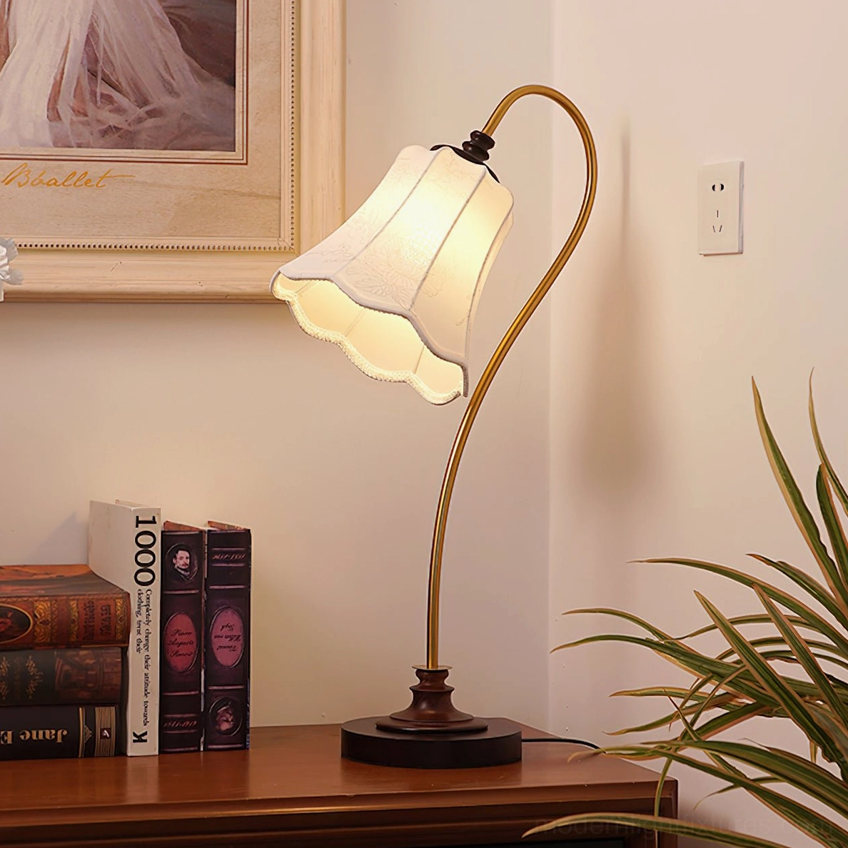 Retro fabric shade table lamp on home study desk with books and wall art - warm lighting ambiance