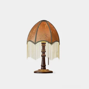 Vintage tassel bead table lamp front view with bamboo print fabric shade and gold metal fringe on wooden base