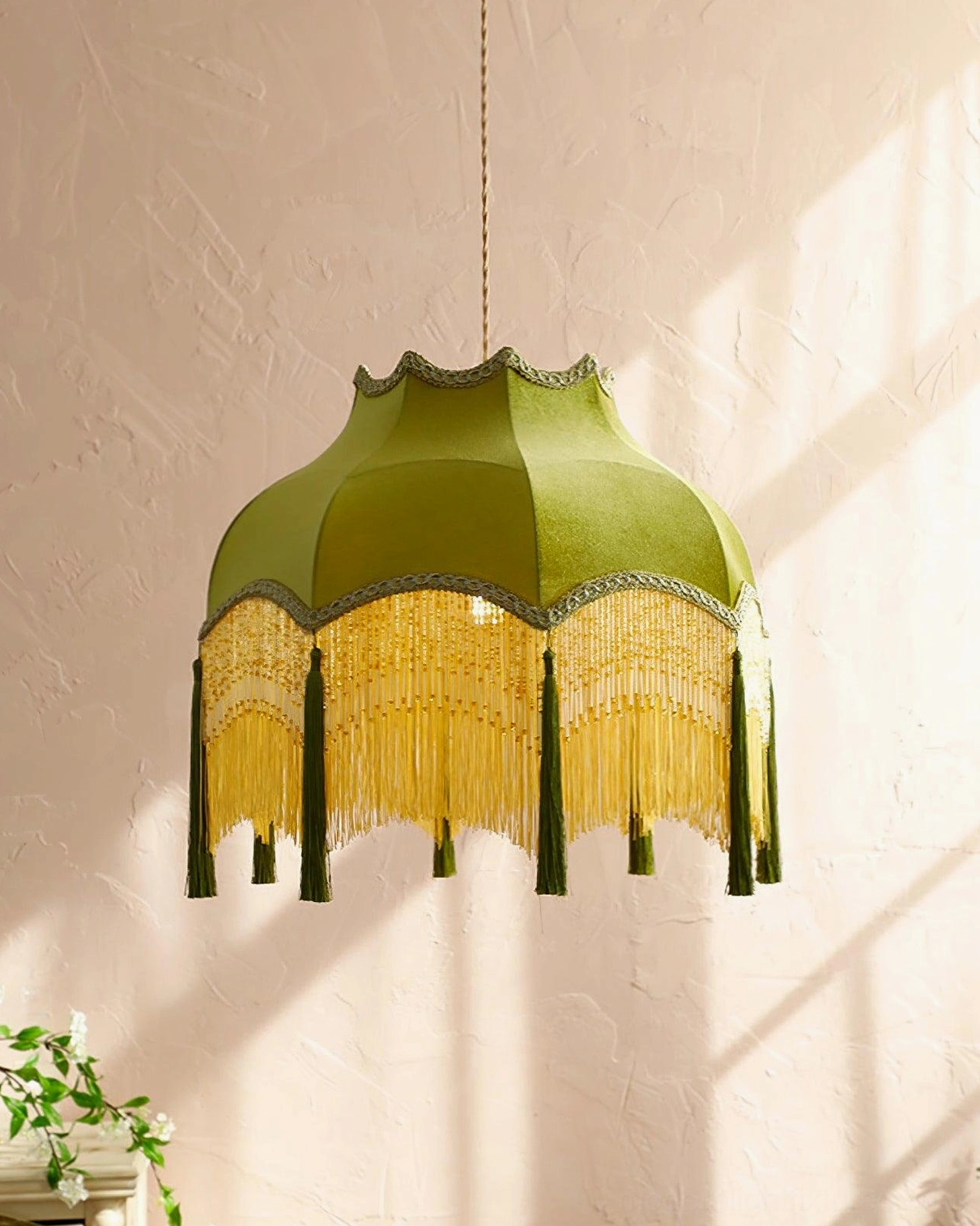 Vintage tassel pendant light in romantic bohemian style against textured pink wall