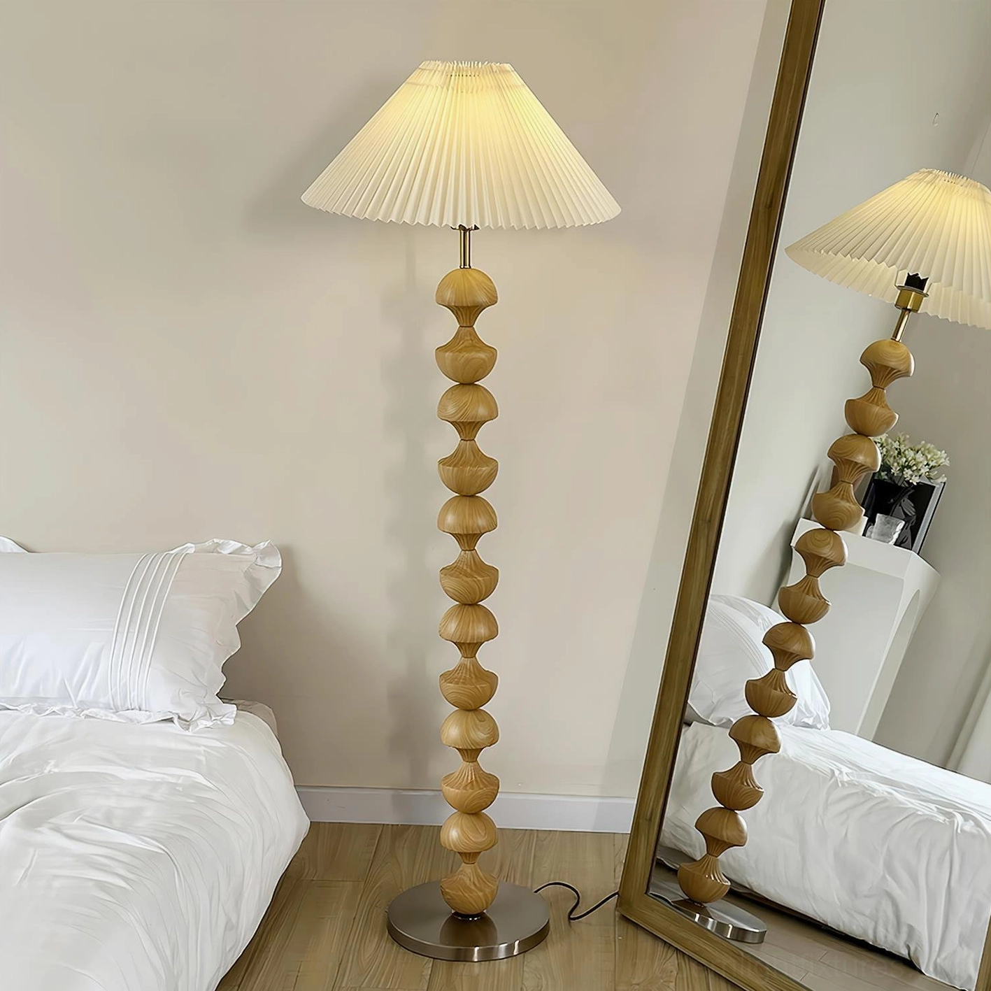 Natural light wood beaded floor lamp in bedroom setting with full-length mirror, light yellow wood grain pole and silver metal base, ambient lighting
