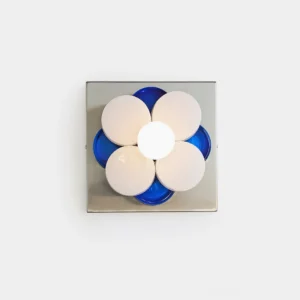 Violetta modern flower wall sconce with chrome base and blue frosted glass petals, frontal view on white wall