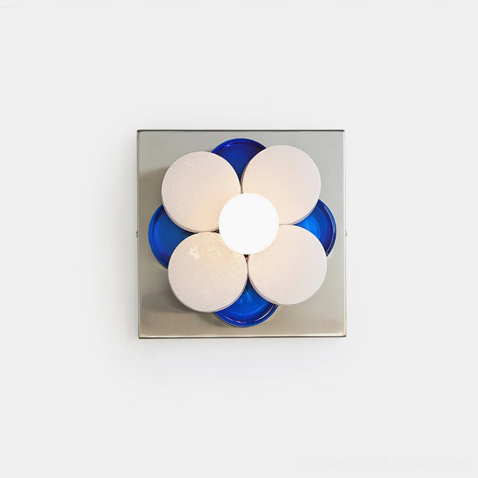 Violetta modern flower wall sconce with chrome base and blue frosted glass petals, frontal view on white wall